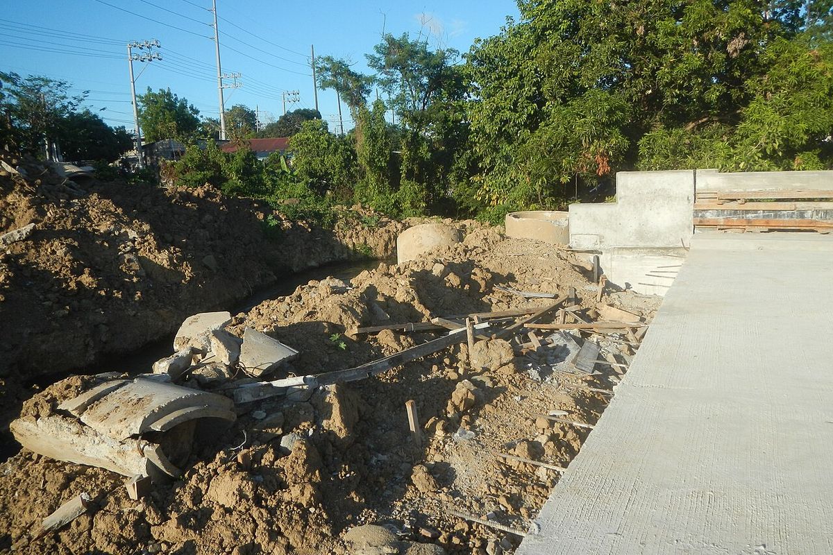 Placa de concreto de una obra vial junto a una zanja